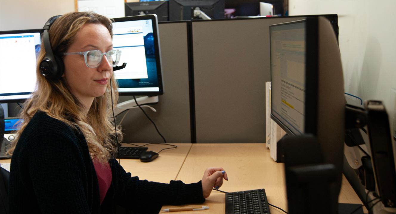 female dispatcher with headset looking at computer monitor