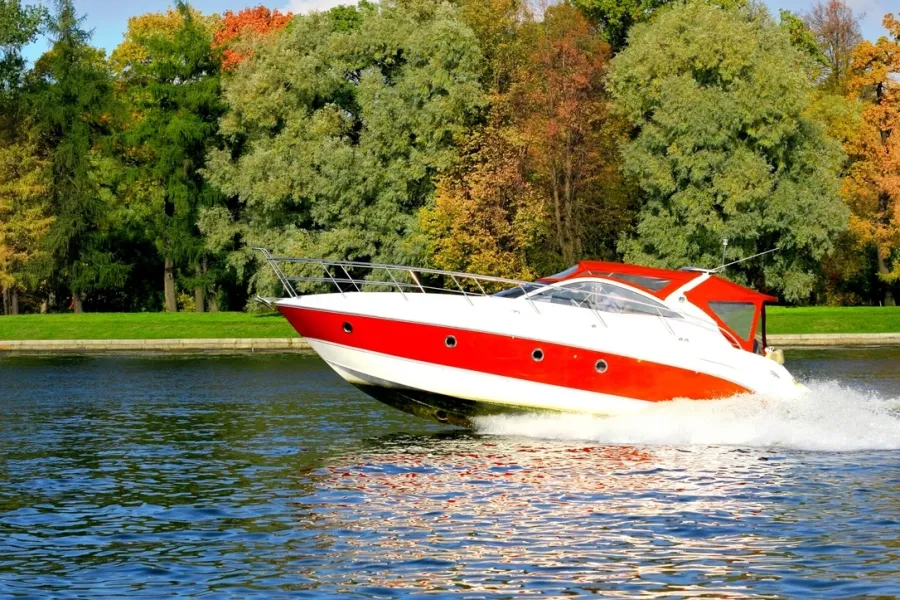 red and white boat zipping by on water