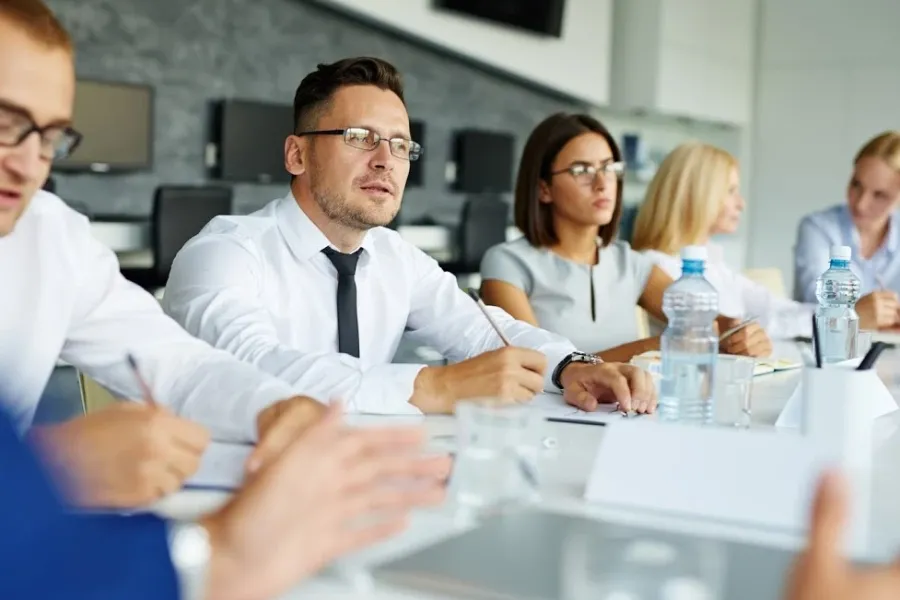 group of people sitting at desk in a business meeting