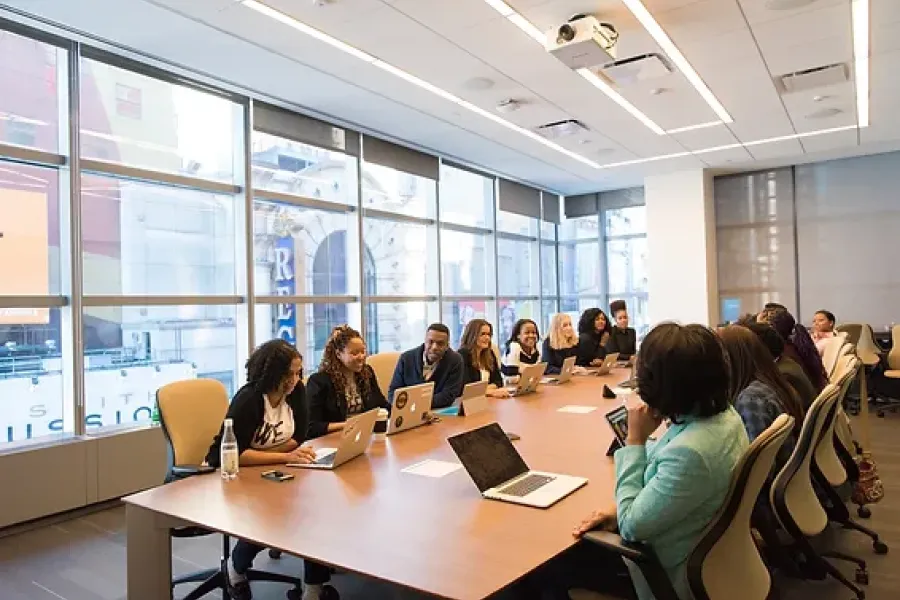 group of people sitting around large table in business meeting