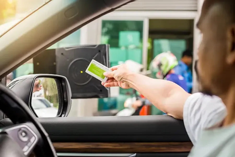 passenger in vehicle scanning card at parking lot