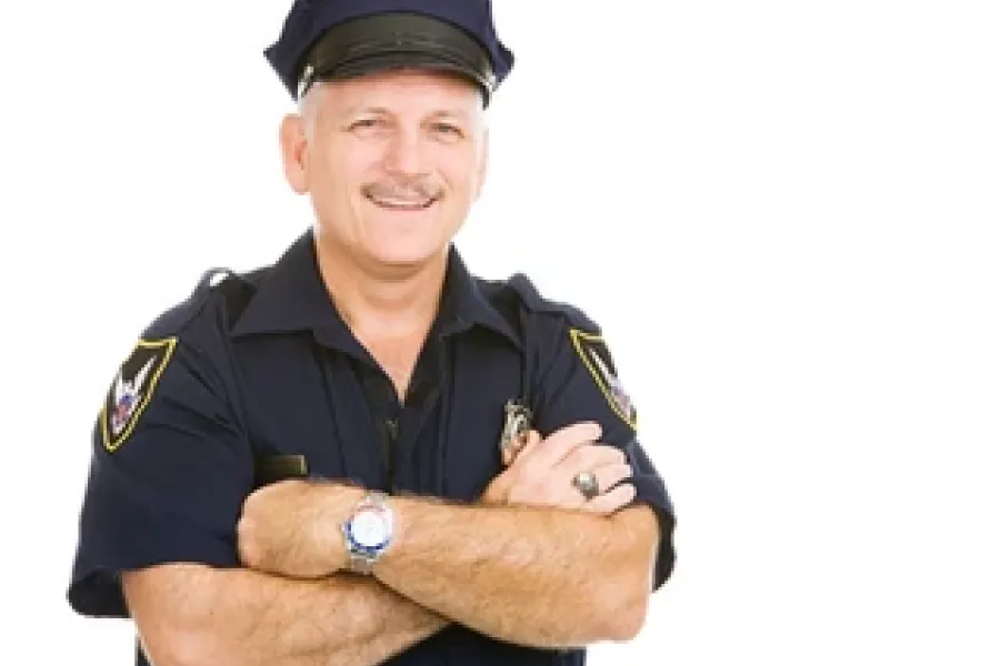 male security guard smiling at camera with arms crossed in front of chest