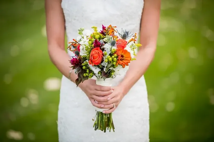 bride in white dress holding bouquet of flowers