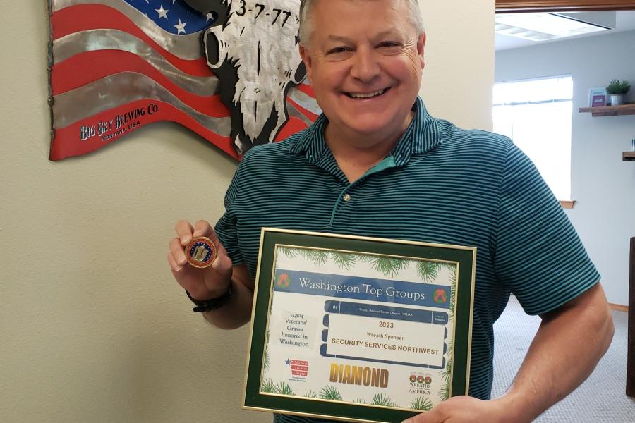 joe holding diamond award and coin from daughters of the american revolution