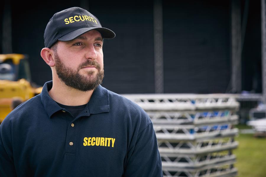 male security officer standing outside by stage