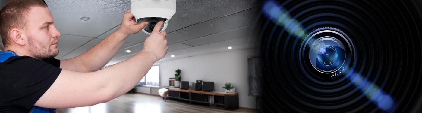 man installing security camera on ceiling of house