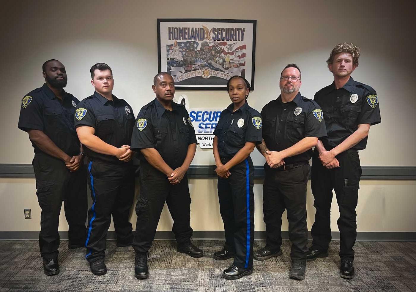 six male and female security officers in uniform