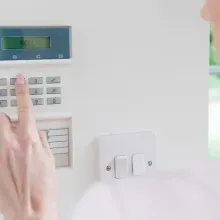 person inputting code into alarm panel