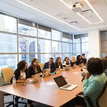 group of people sitting around large table in business meeting