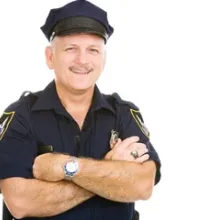 male security guard smiling at camera with arms crossed in front of chest