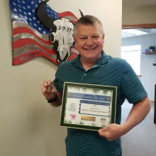 joe holding diamond award and coin from daughters of the american revolution