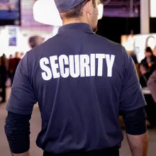 closeup of back of security guard in uniform patrolling event