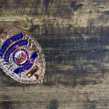 close up of security officer badge on wood background