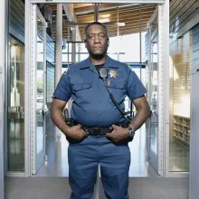 security officer standing in entrance to school looking at camera