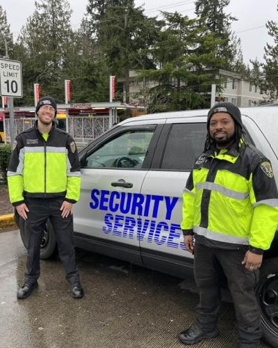 two officers in front of security vehicle