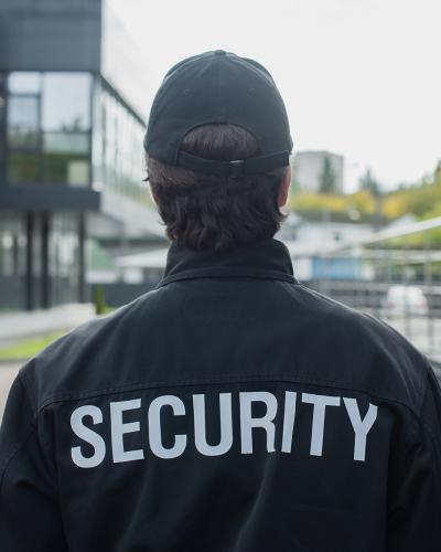 back of security officer outside, jacket says security on back