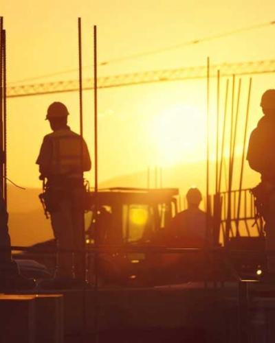 construction site workers at sunset