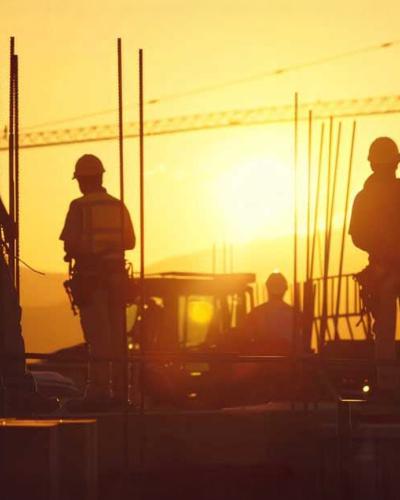 construction site workers at sunset