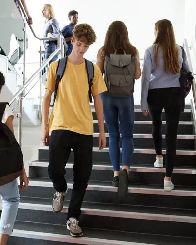 high school students walking on stairs in school